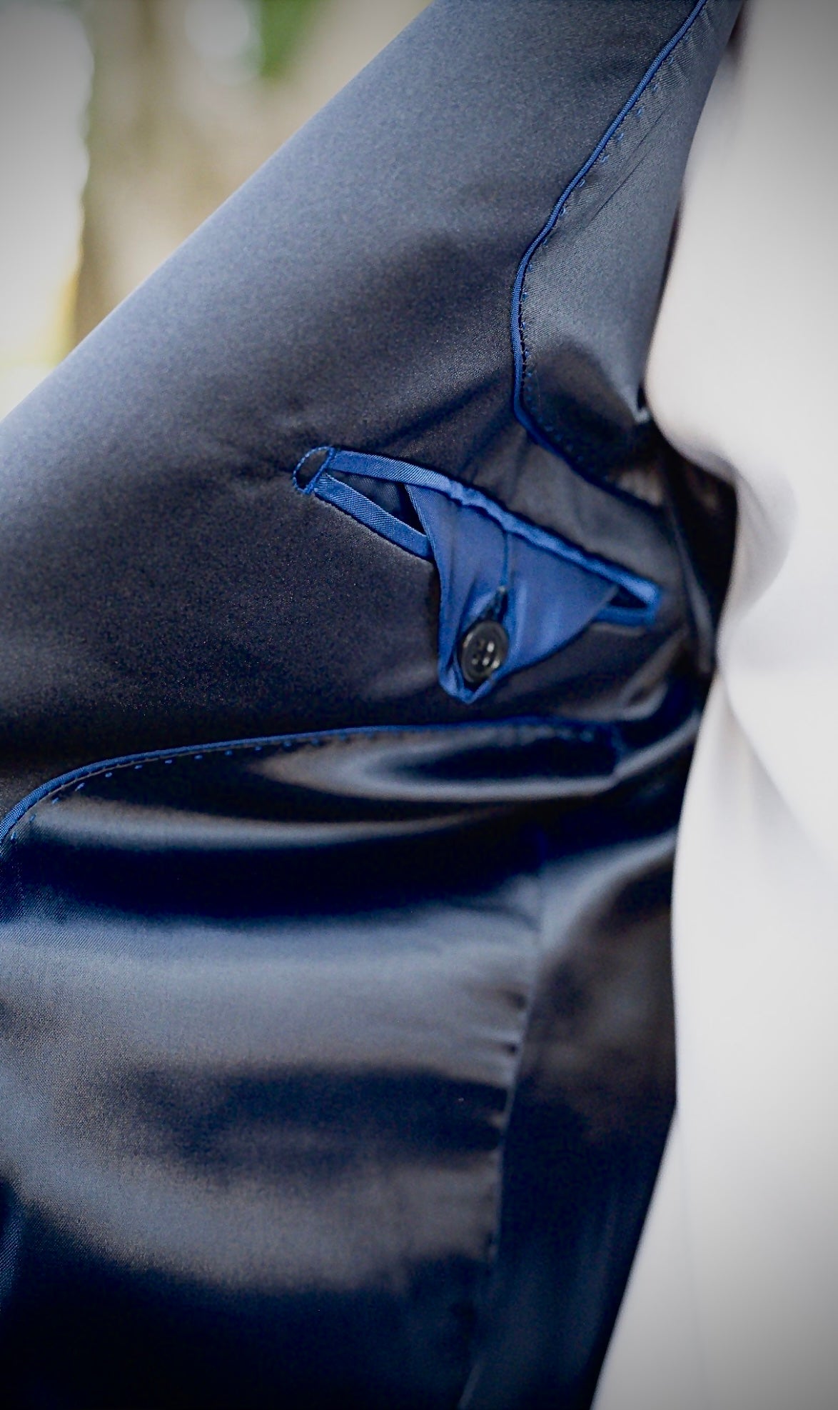 Close-up of a navy blue jacket with a white shirt underneath