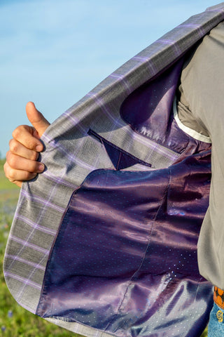 Person holding a purple and gray plaid fabric against a blue sky. Inside pattern is bright, fun, and iridescent light reflection when in the sun. 
