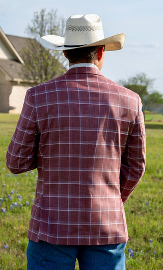 Person wearing a plaid jacket and cowboy hat in an outdoor setting